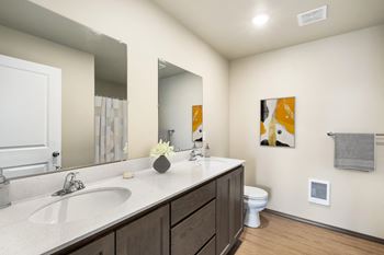 A bathroom with a large mirror and a sink and a toilet